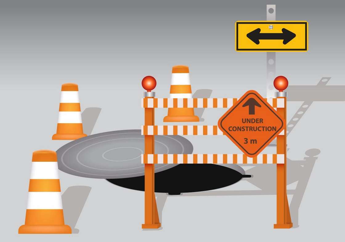 Manhole With Cone And Board Warning