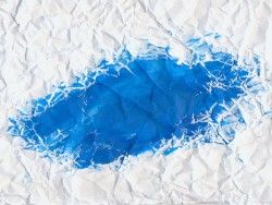 Wrinkled paper with blue paint background
